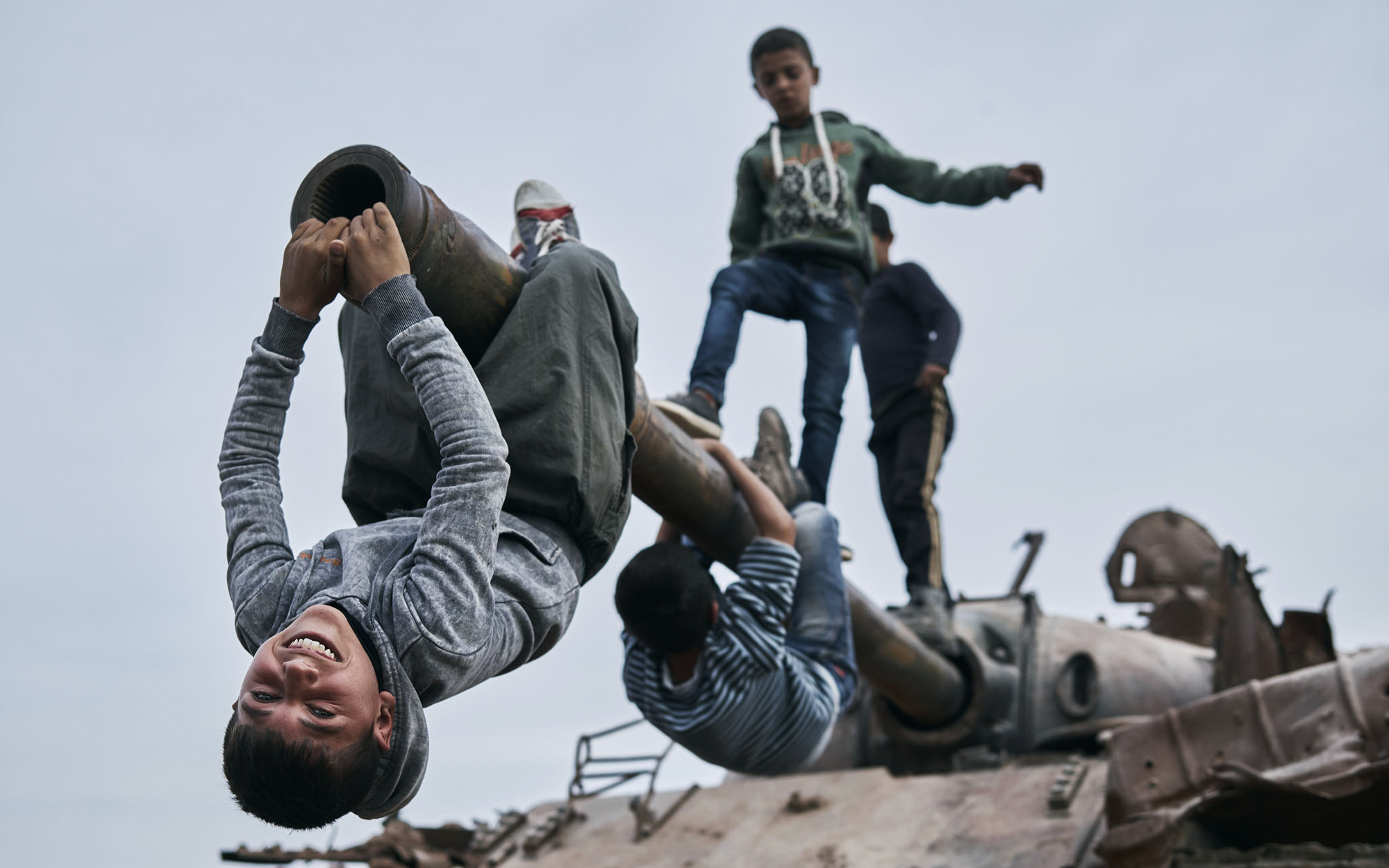 Des enfants kurdes de Kobanê jouant sur un char détruit